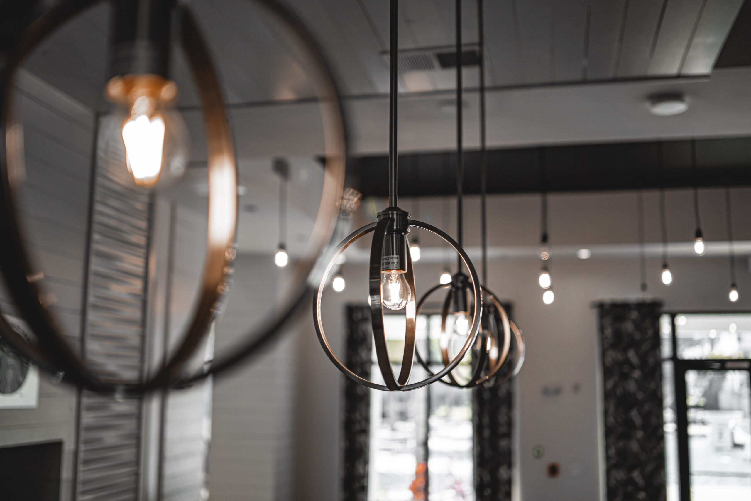 A selective focus shot of a modern lamp with a light bulb inside the building